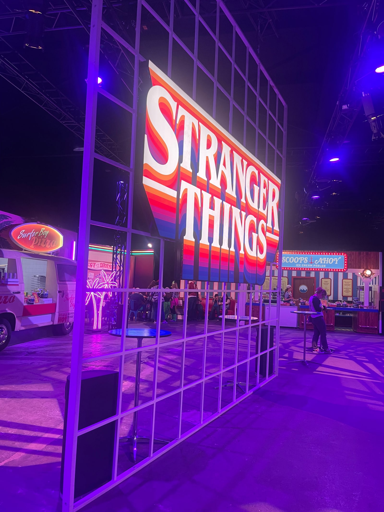 Multicolored Stranger Things sign inside Mix-Tape, with Surfer Boy Pizza and Scoops Ahoy